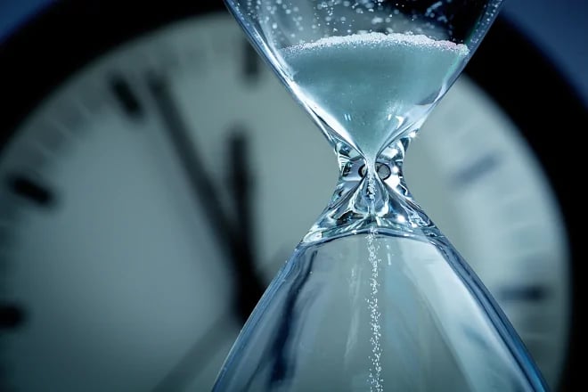 hourglass in front of clock