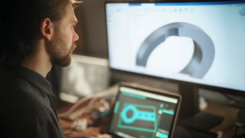 man designing a metal component on a pc